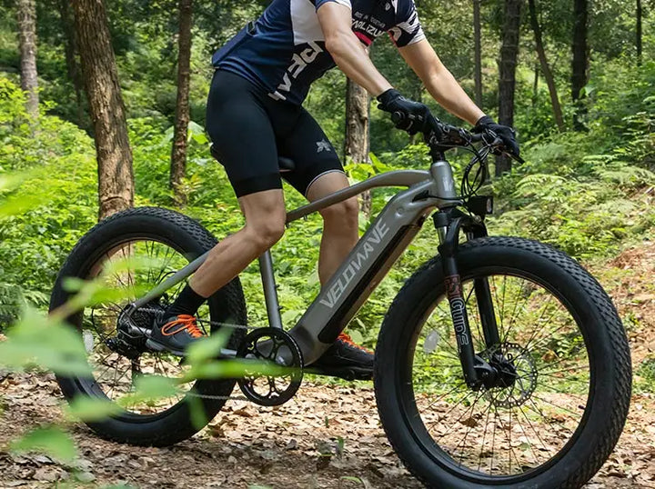 man riding velowave ebike in a forest